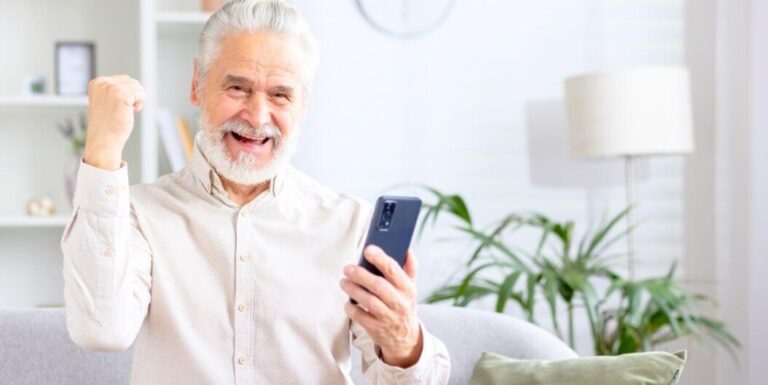 Happy Elderly Man Holding His Smartphone at Assisted Living Facility