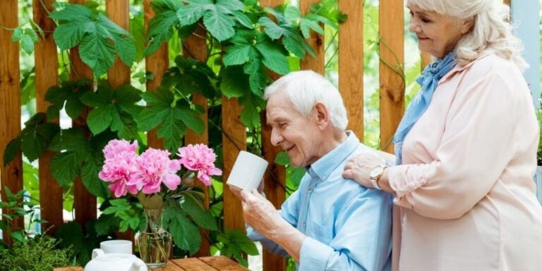 Elderly Couple Enjoying Morning Coffee Together on a Patio at a Memory Care Facility