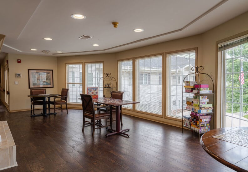 Bright Activity Room with Game Tables by Windows at an Assisted Living Community Bright Activity Room with Game Tables by Windows at an Assisted Living Community