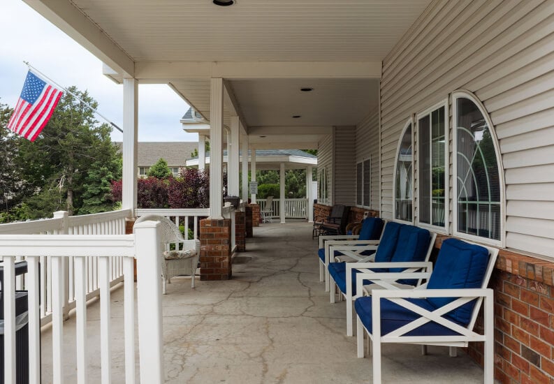 Covered Front Porch with Seating and Flag at an Assisted Living Community Covered Front Porch with Seating and Flag at an Assisted Living Community