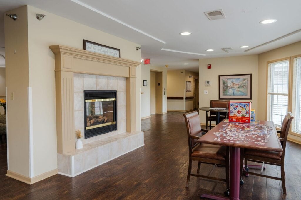Common Area with a Fireplace and Puzzle Table at an Assisted Living Community